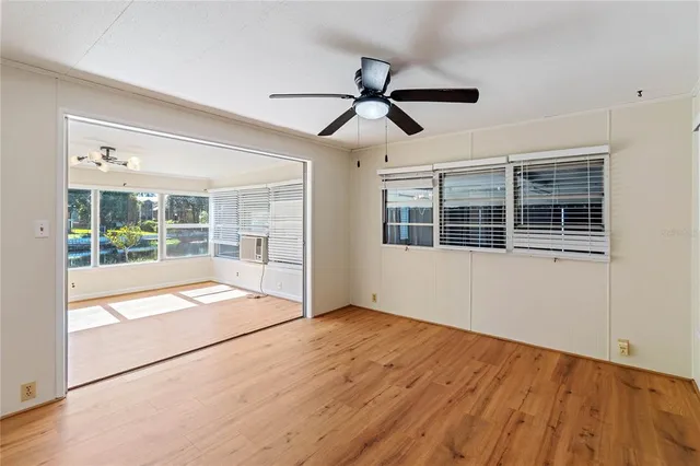 a view of empty room with wooden floor and windows