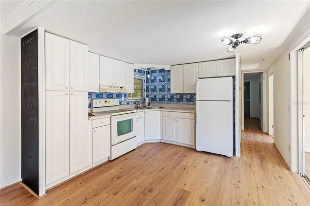 a kitchen with a refrigerator a stove top oven a sink and cabinets