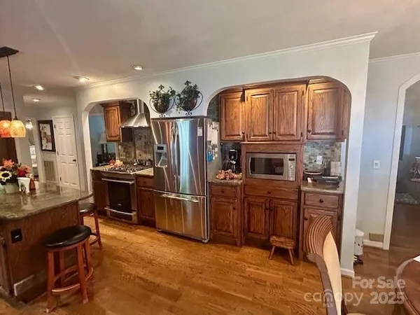 a kitchen with stainless steel appliances granite countertop a refrigerator and a stove top oven