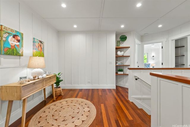 a living room with wooden floor and a chair