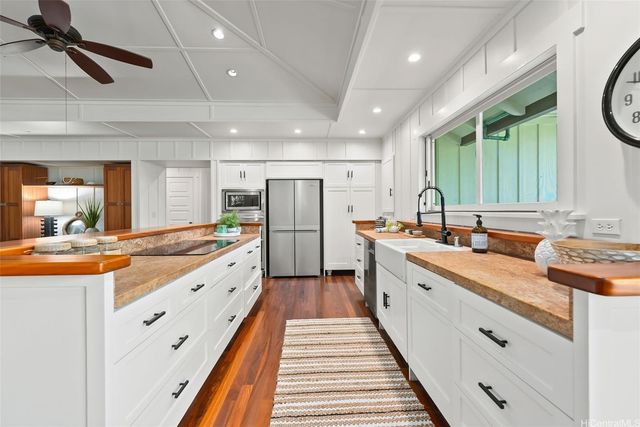 a large kitchen with stainless steel appliances granite countertop a lot of counter space and a wooden floors