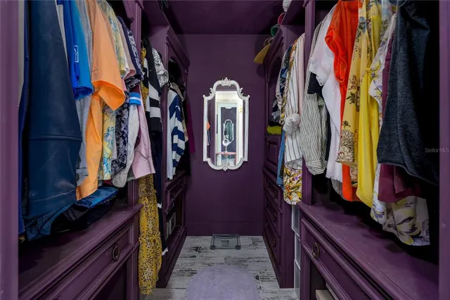 a view of walk in closet with clothes and shoes