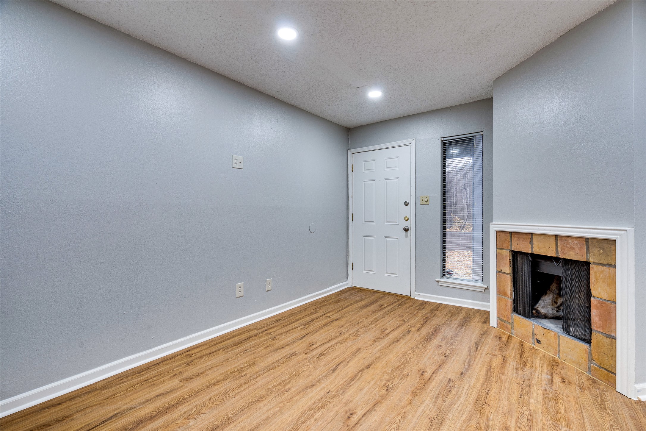 1808 Rio Grande Street, Unit 6 Austin, TX 78701 - Photo 4 of 29 Entryway with a textured ceiling, light wood-style flooring, a tiled fireplace, and recessed lighting