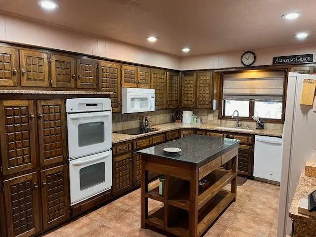 a kitchen with kitchen island a stove and a sink