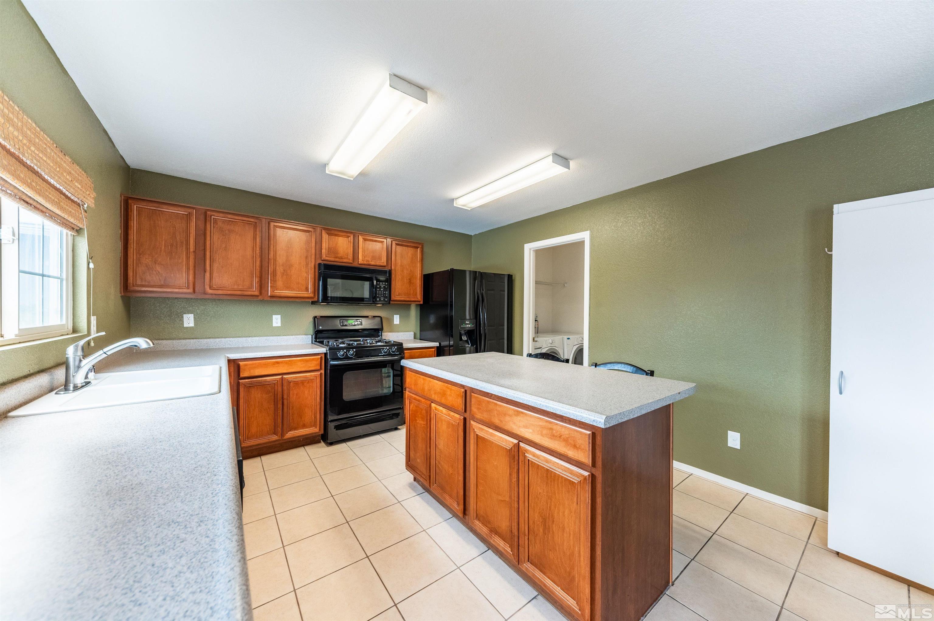 7830 Welsh Drive Reno, NV 89506 - Photo 13 of 27 a kitchen with stainless steel appliances granite countertop a stove top oven a sink dishwasher and a refrigerator