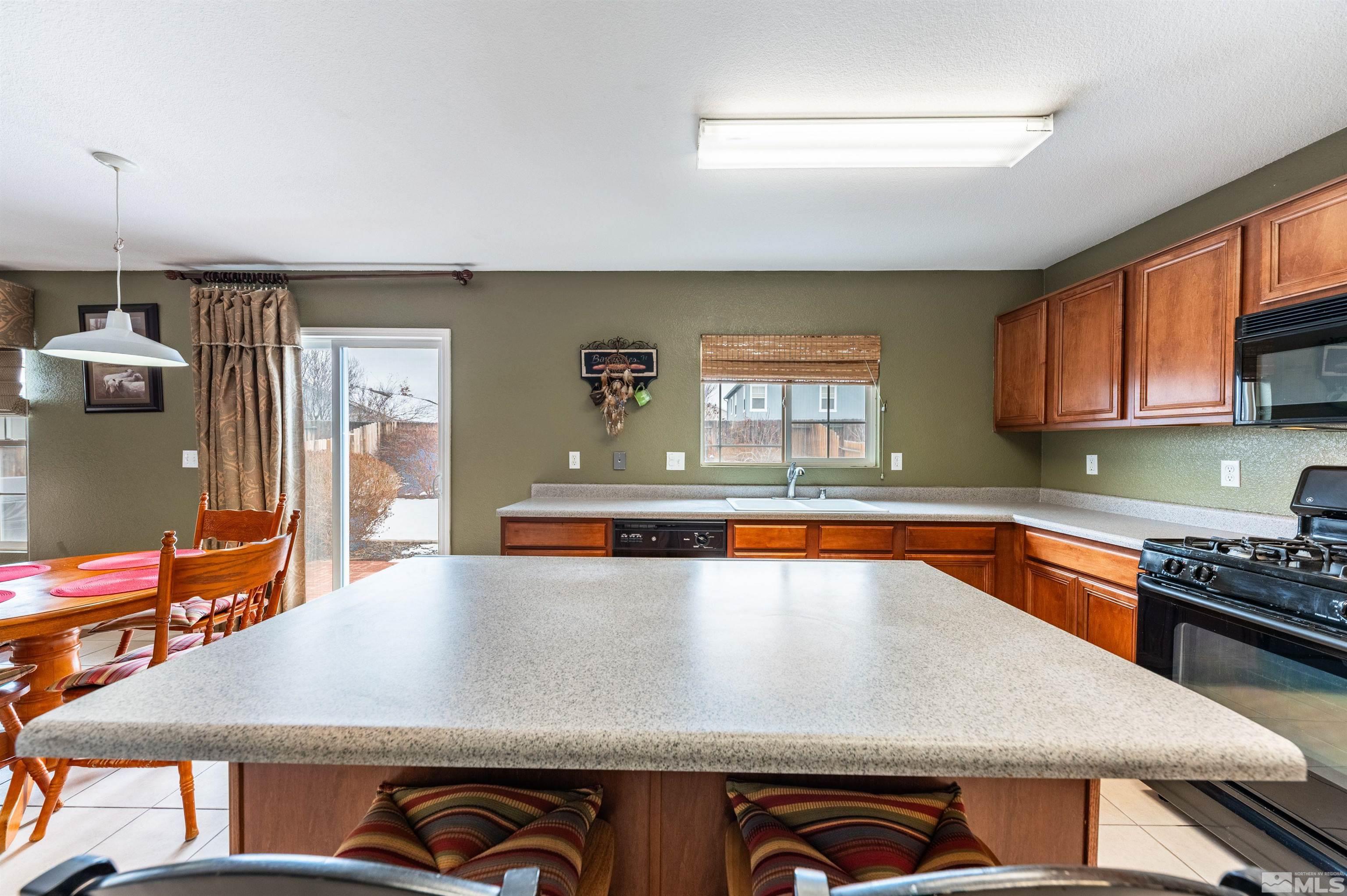 7830 Welsh Drive Reno, NV 89506 - Photo 15 of 27 a view of a kitchen with a sink and dishwasher a stove top oven with wooden floor