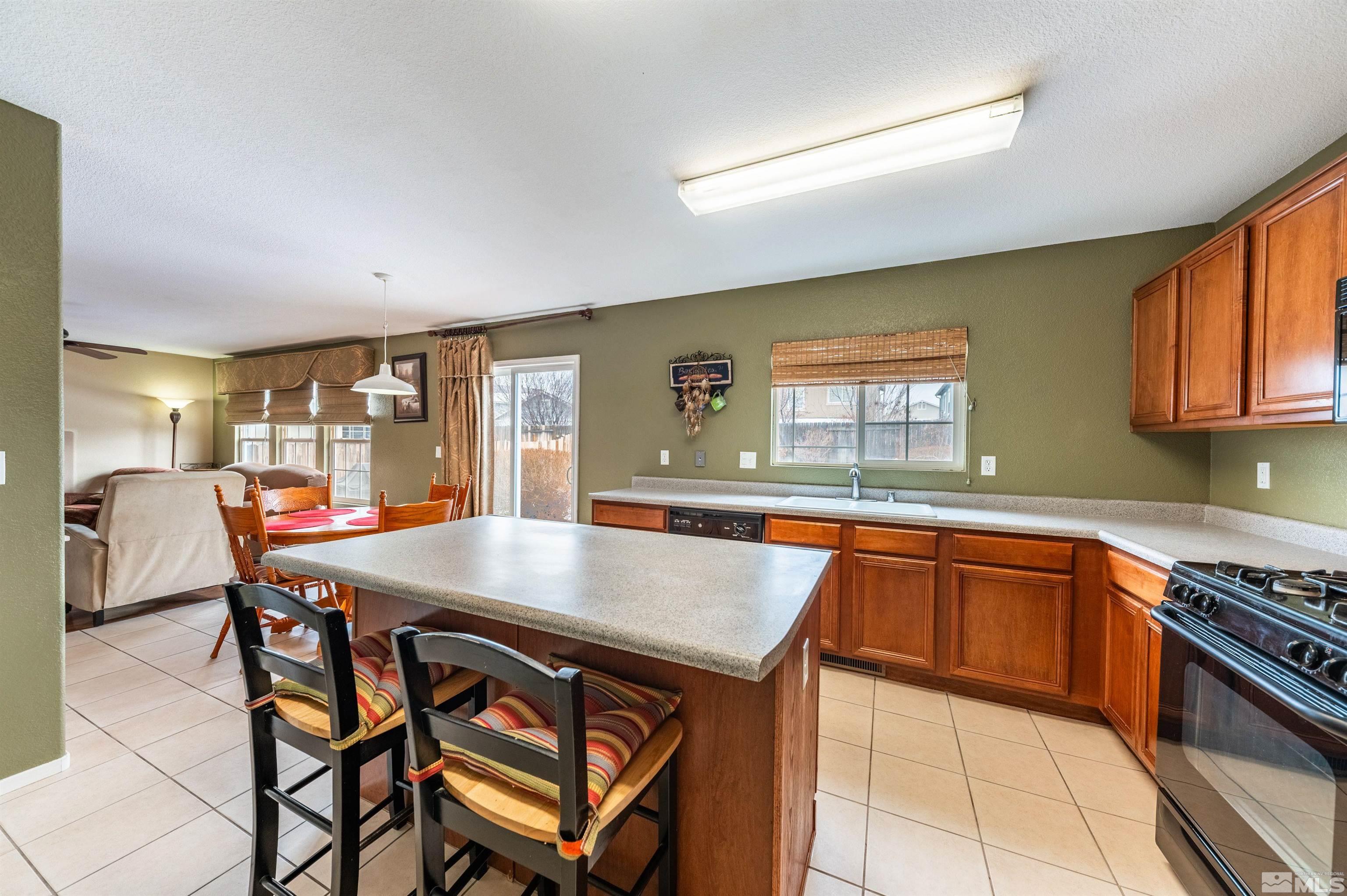 7830 Welsh Drive Reno, NV 89506 - Photo 16 of 27 a kitchen with stainless steel appliances granite countertop a stove a sink dishwasher and cabinets with wooden floor
