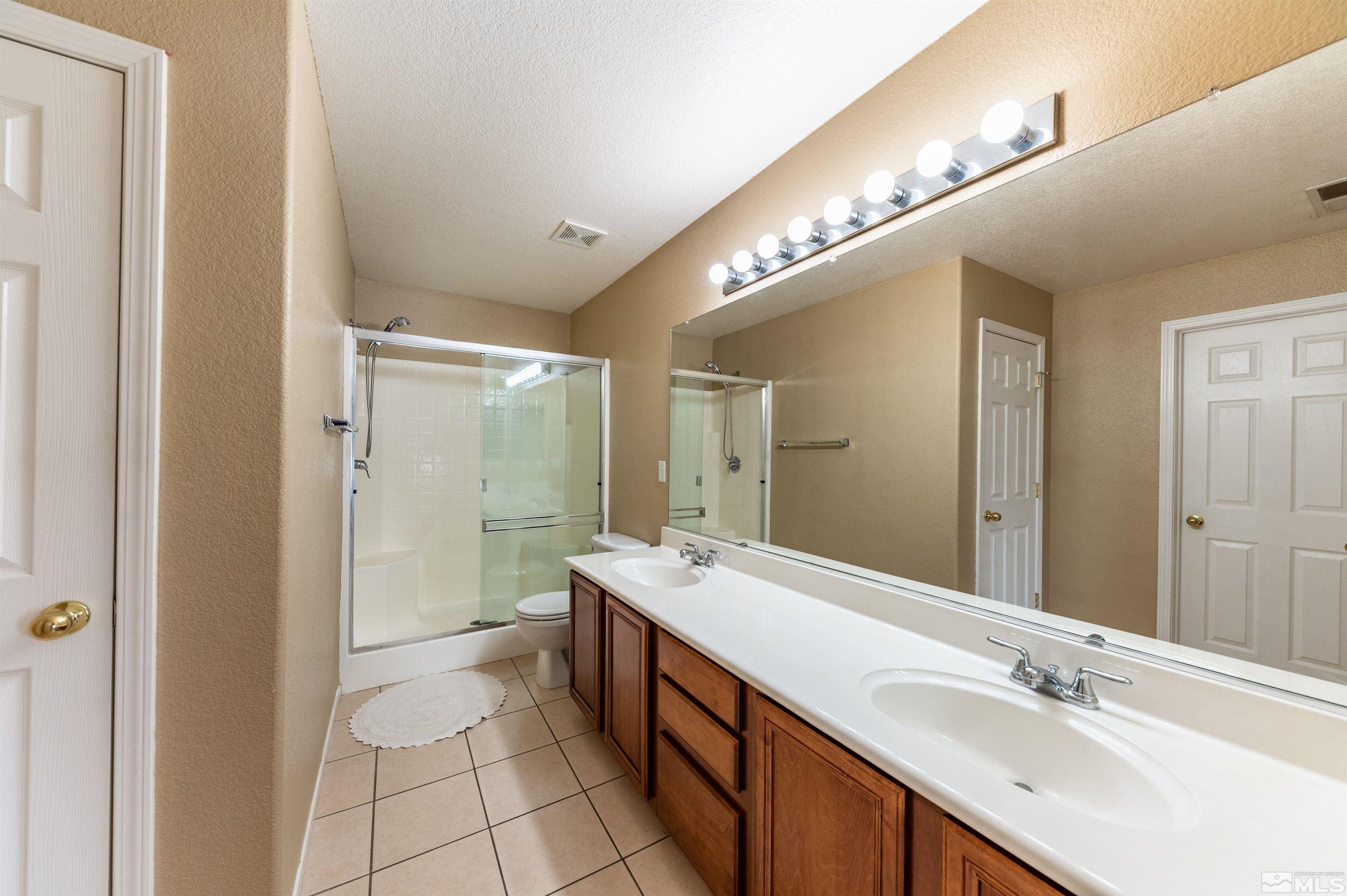 7830 Welsh Drive Reno, NV 89506 - Photo 21 of 27 a spacious bathroom with a double vanity sink a mirror and a shower