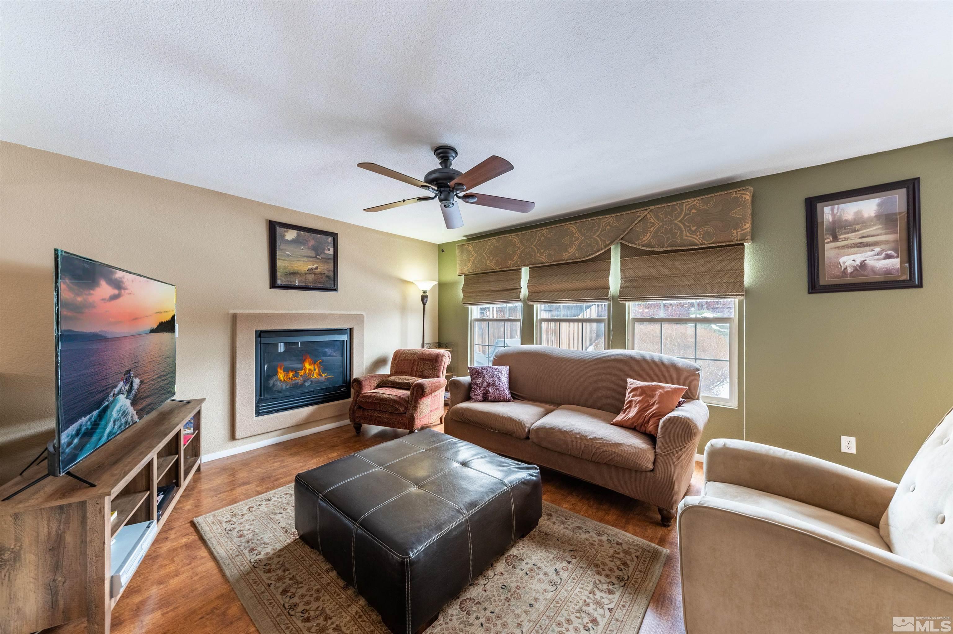 7830 Welsh Drive Reno, NV 89506 - Photo 10 of 27 a living room with furniture a flat screen tv and a fireplace