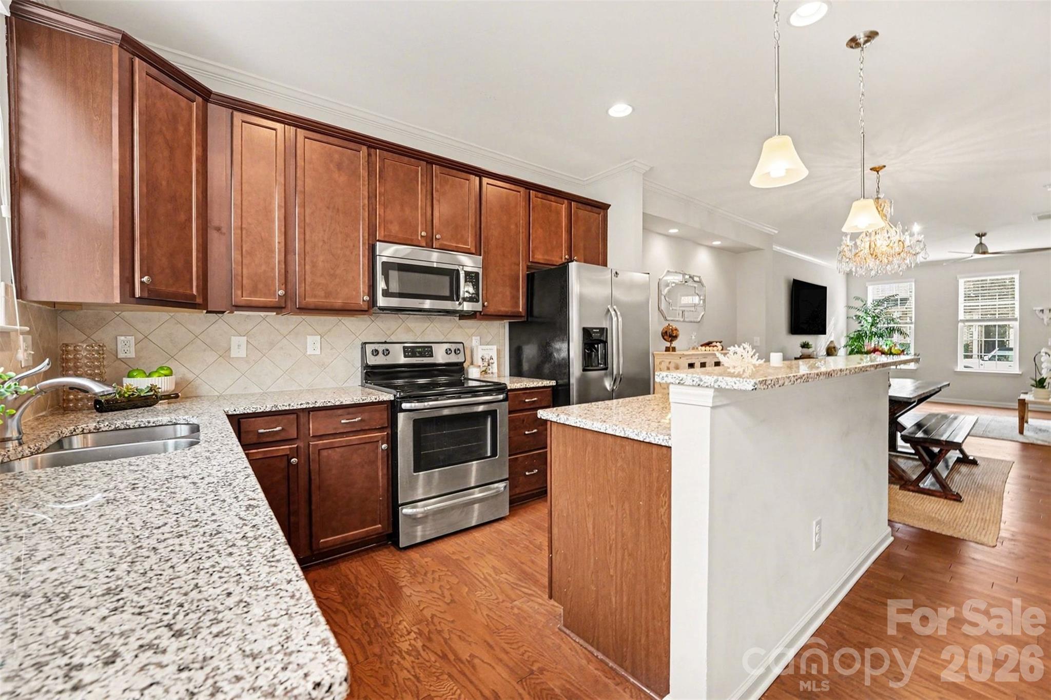 1225 Assembly Street Belmont, NC 28012 - Photo 9 of 17 a kitchen with kitchen island granite countertop a stove top oven a sink dishwasher and a refrigerator with wooden floor