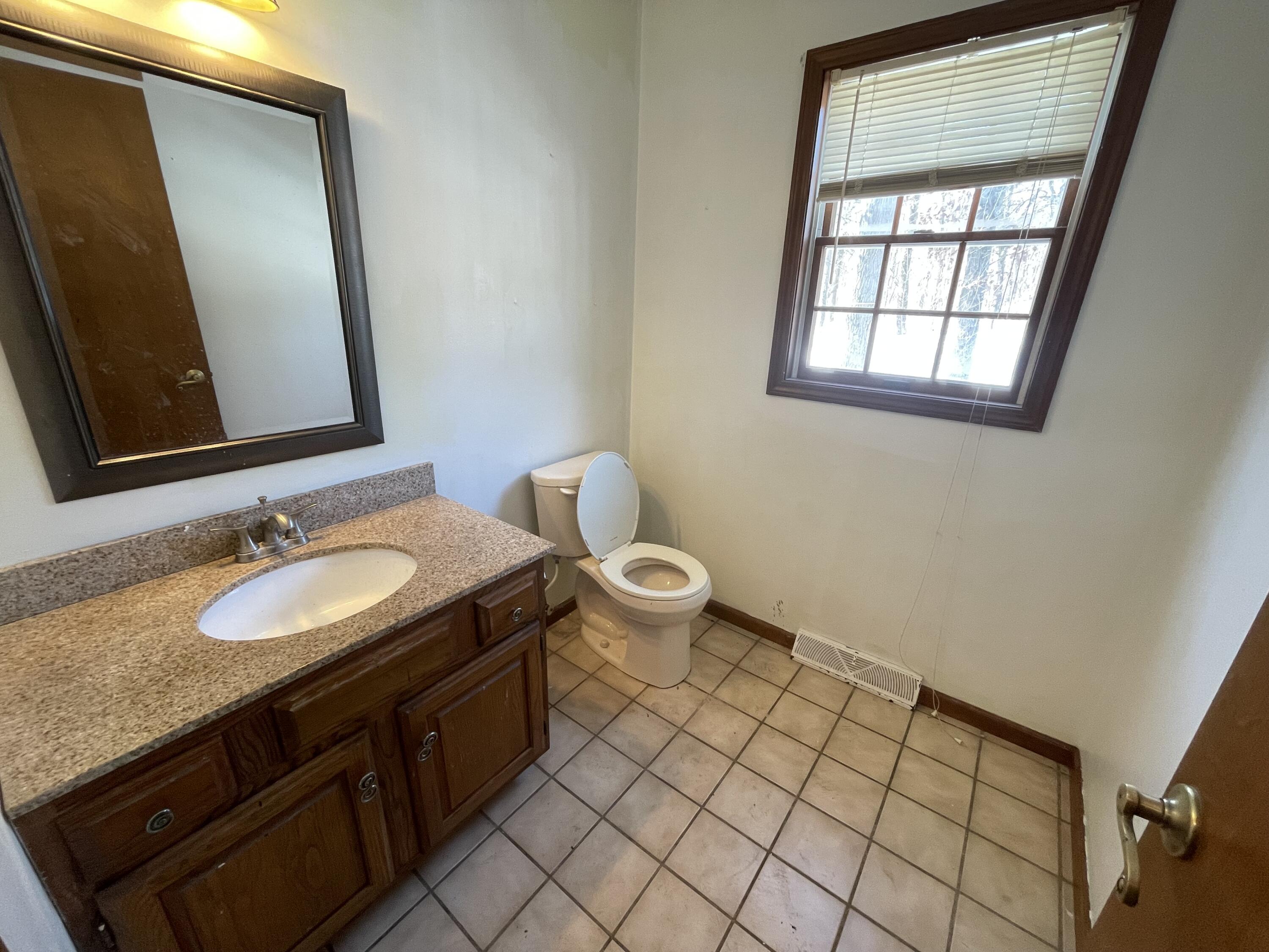 9710 Rustic Drive Demotte, IN 46310 - Photo 12 of 31 a bathroom with a granite countertop sink toilet and mirror