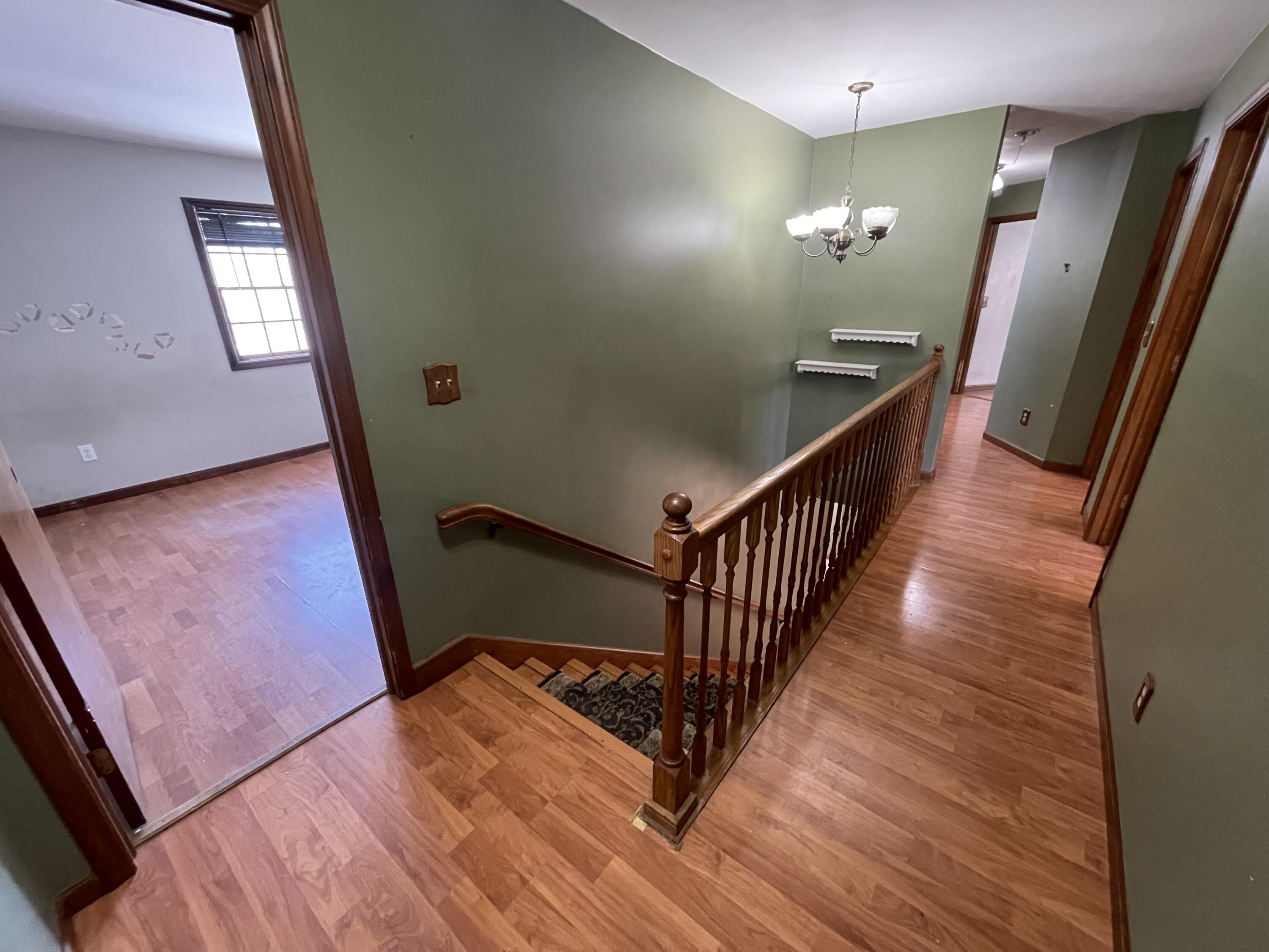 9710 Rustic Drive Demotte, IN 46310 - Photo 13 of 31 a view of a hallway with wooden floor and stairs