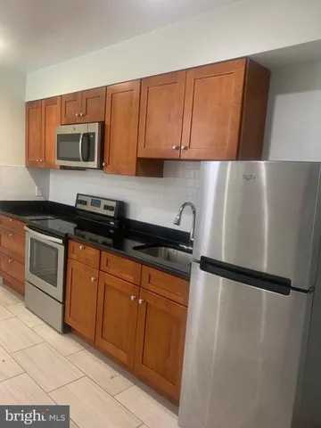 a kitchen with stainless steel appliances granite countertop a refrigerator sink and cabinets