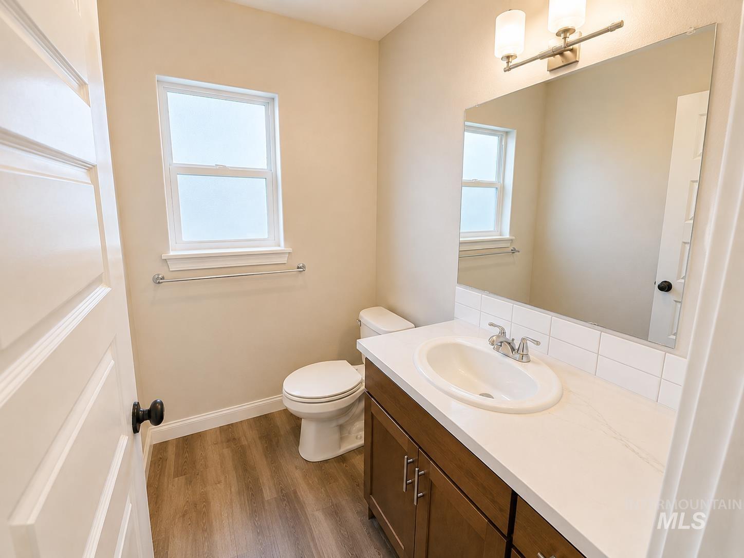 983 Quartz Road Kimberly, ID 83341 - Photo 16 of 18 Vanity with integrated sink, wood-finish cabinetry, sleek countertop, and subway tile backsplash