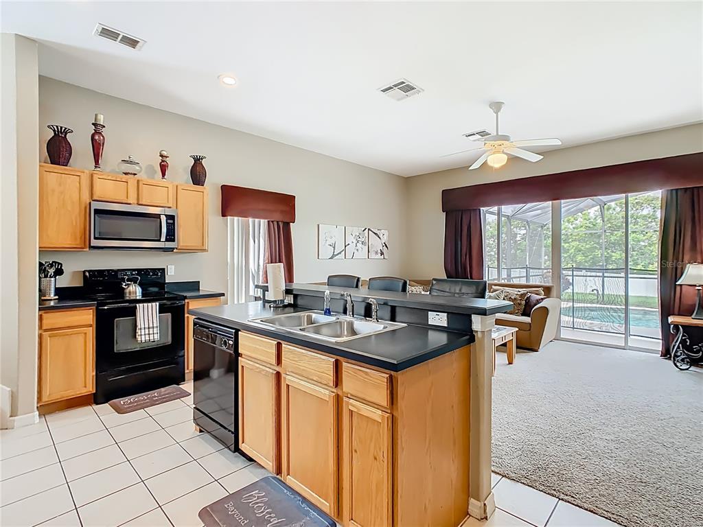 334 Cadiz Loop Davenport, FL 33837 - Photo 21 of 63 a kitchen with stainless steel appliances granite countertop a sink and a stove