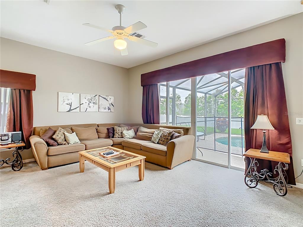 334 Cadiz Loop Davenport, FL 33837 - Photo 25 of 63 a living room with furniture and a large window