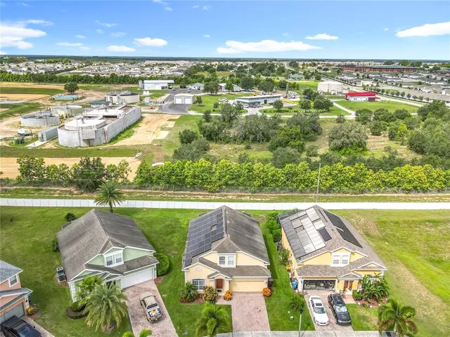 an aerial view of residential houses with outdoor space and ocean view