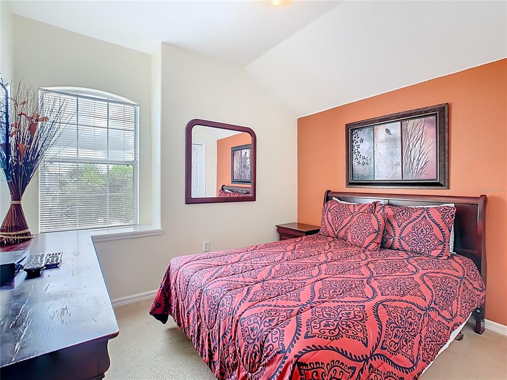 334 Cadiz Loop Davenport, FL 33837 - Photo 35 of 63 a bedroom with a large bed and a window