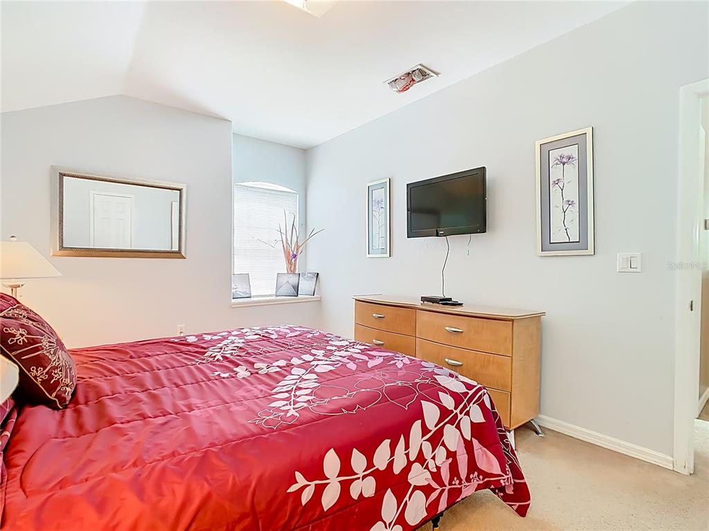 334 Cadiz Loop Davenport, FL 33837 - Photo 37 of 63 a bedroom with a bed and a flat screen tv