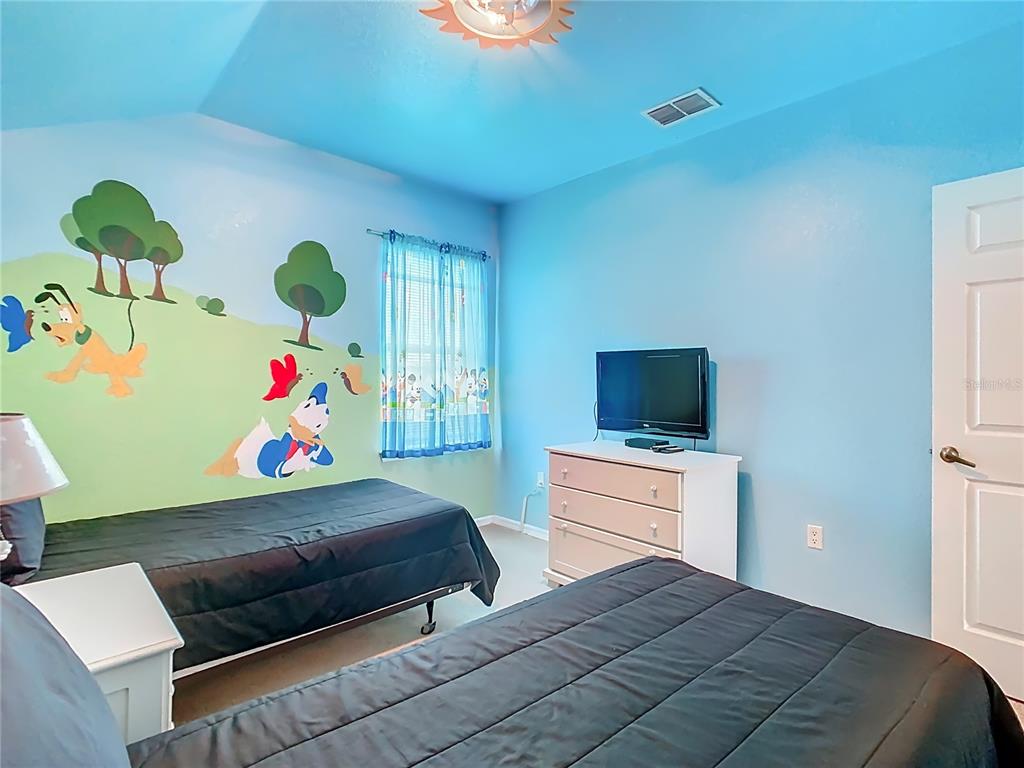 334 Cadiz Loop Davenport, FL 33837 - Photo 40 of 63 a bedroom with a bed and a television