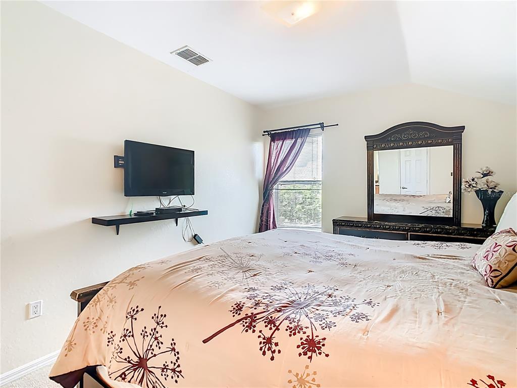 334 Cadiz Loop Davenport, FL 33837 - Photo 43 of 63 a bedroom with a bed and a flat screen tv