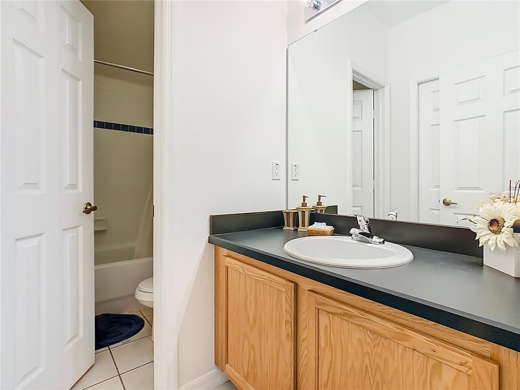 334 Cadiz Loop Davenport, FL 33837 - Photo 48 of 63 a bathroom with a granite countertop sink and a mirror