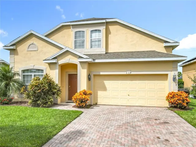 a front view of a house with a garden and plants