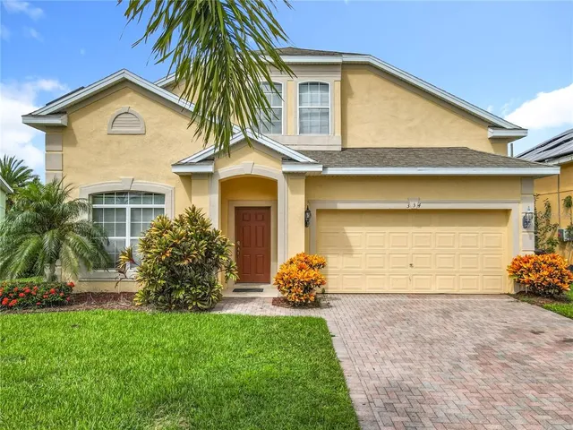 a front view of a house with a garden and plants