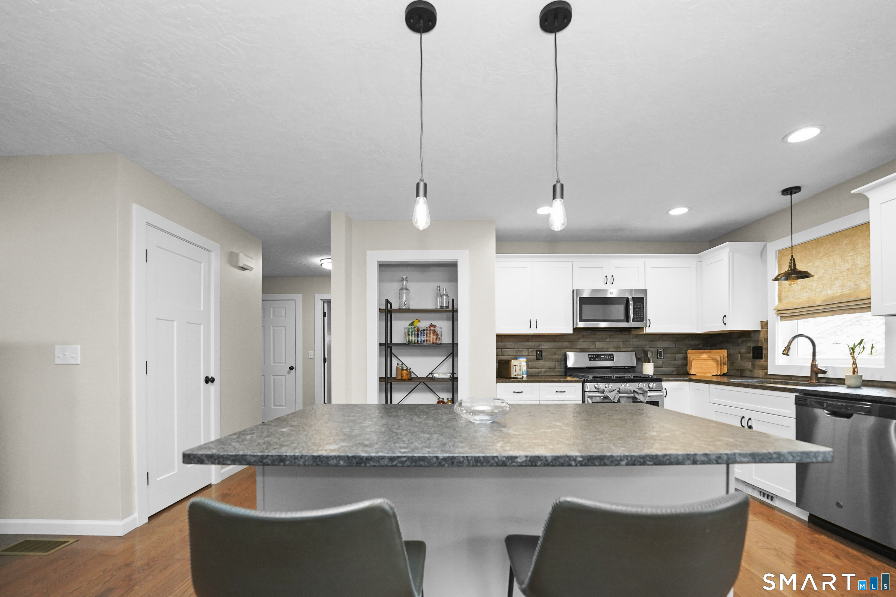 42 Chapman Chase, Unit 42 Windsor Locks, CT 06096 - Photo 13 of 38 a kitchen with stainless steel appliances granite countertop a sink a microwave a refrigerator and white cabinets
