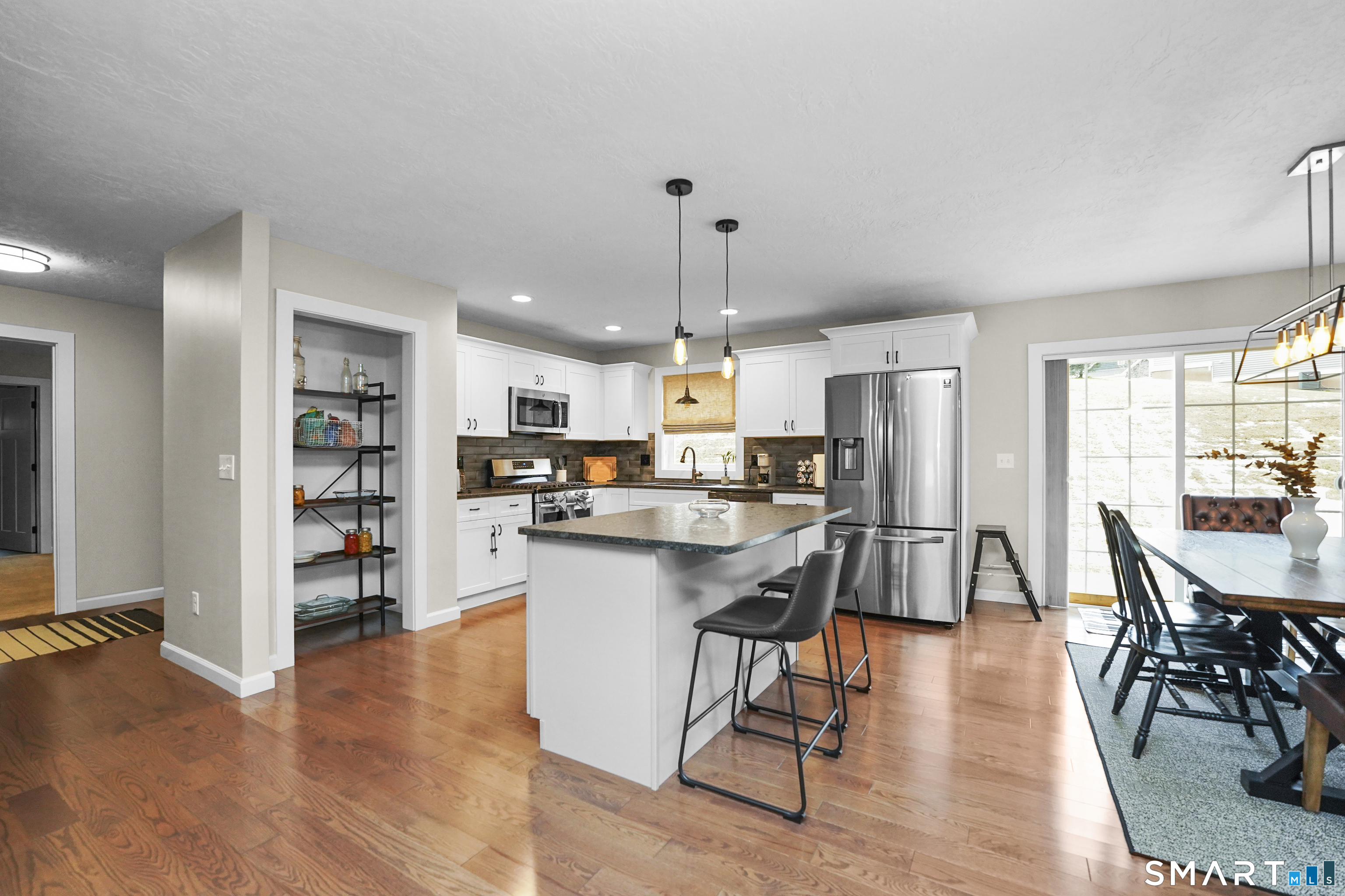 42 Chapman Chase, Unit 42 Windsor Locks, CT 06096 - Photo 10 of 38 a kitchen with stainless steel appliances granite countertop a refrigerator a stove top oven a dining table and chairs with wooden floor