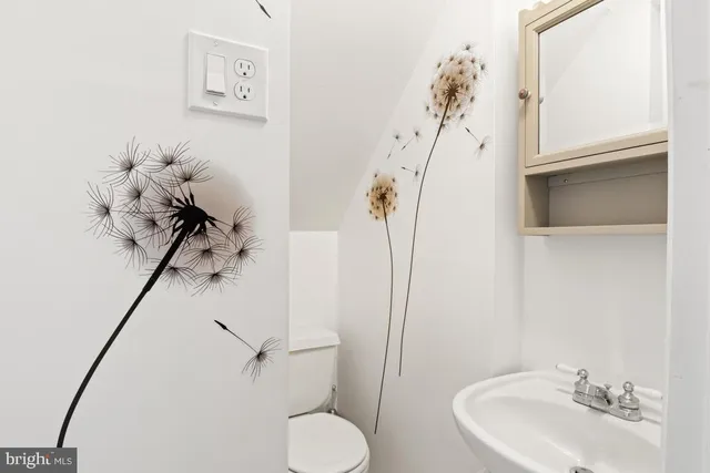 a bathroom with a sink mirror and toilet
