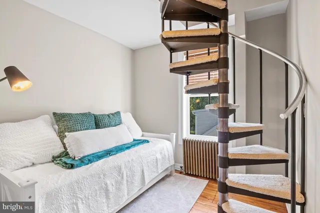 a bedroom with a bed a mirror and a night stand