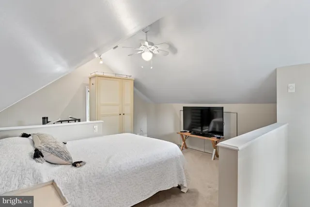 a bedroom with a large bed and a flat tv screen on dresser