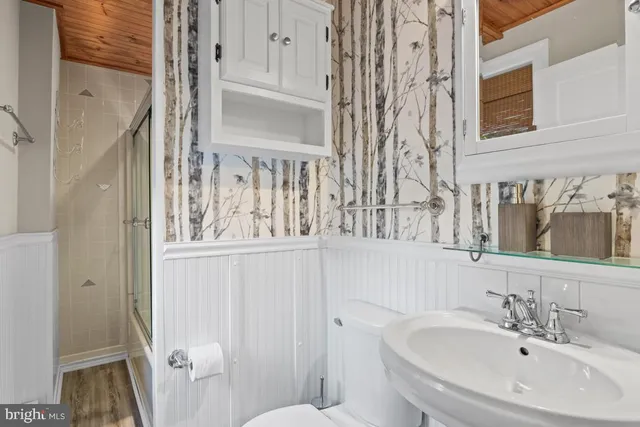 a bathroom with a sink and mirror with toilet