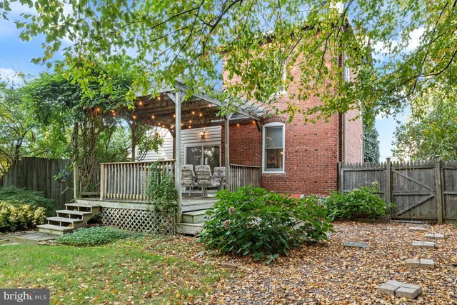 a view of a backyard with table and chairs and a large tree