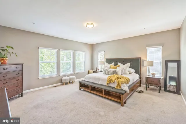 a bed sitting in a bedroom next to a window with lamp