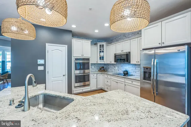 a kitchen with stainless steel appliances granite countertop a sink refrigerator and cabinets