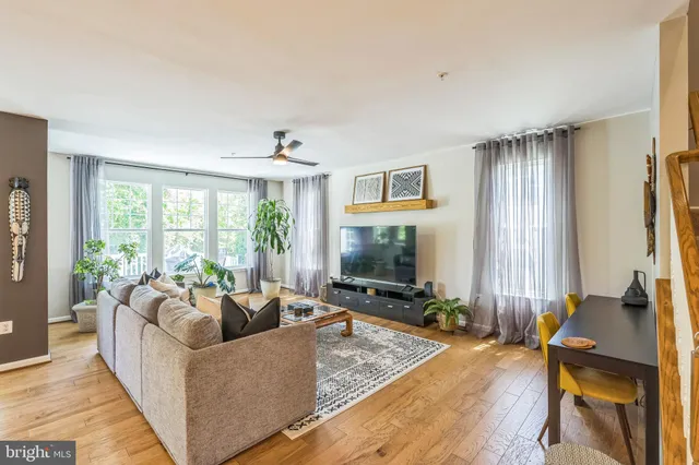 a living room with furniture flat screen tv and a large window
