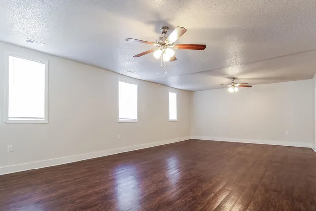 a view of an empty room with wooden floor