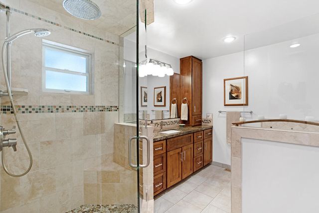 a bathroom with a granite countertop sink a mirror and a shower