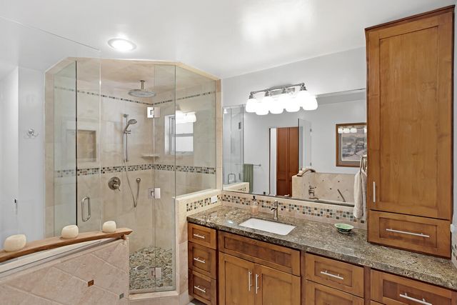 a spacious bathroom with a granite countertop sink mirror and shower