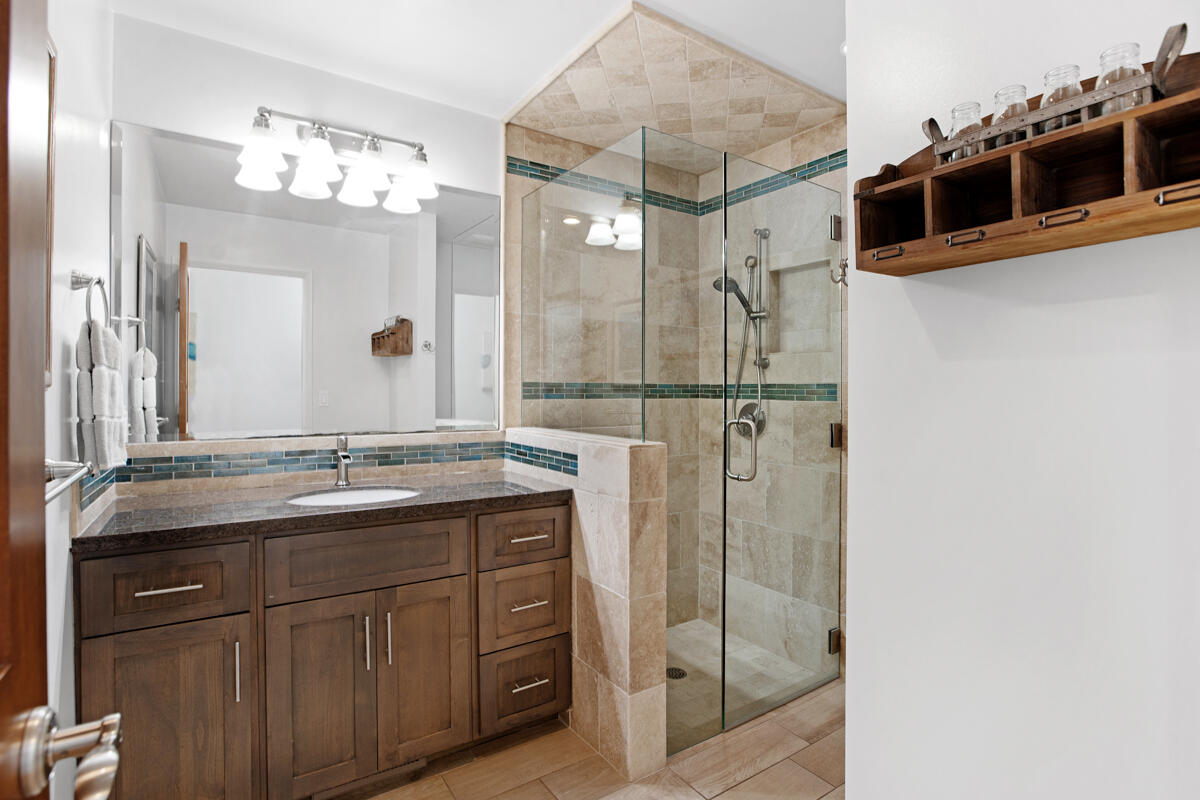 4009 Primavera Road Santa Barbara, CA 93110 - Photo 26 of 41 a bathroom with a granite countertop sink a mirror and shower