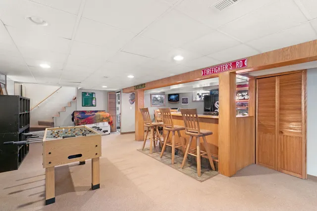 a room with stainless steel appliances kitchen island granite countertop dining table chairs and a refrigerator