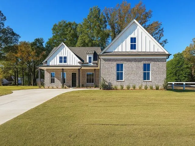a front view of a house with yard and trees