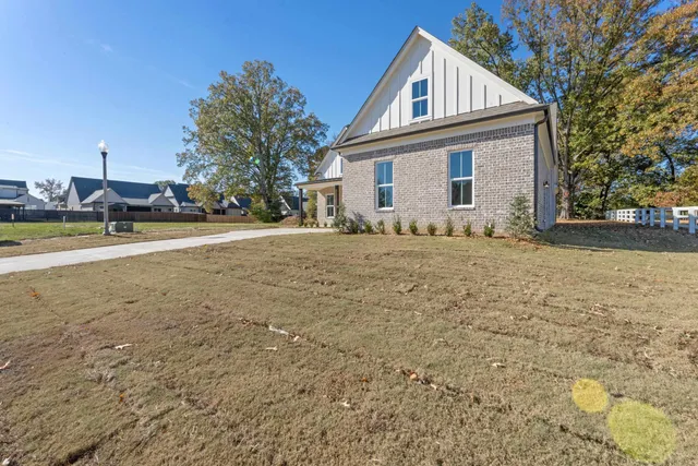 a view of a house with a yard and fence