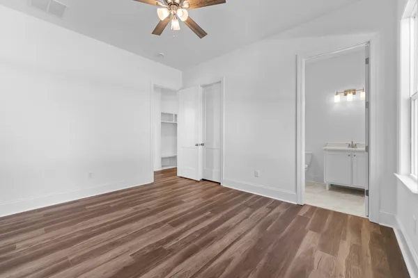 a view of a room with wooden floor and ceiling fan