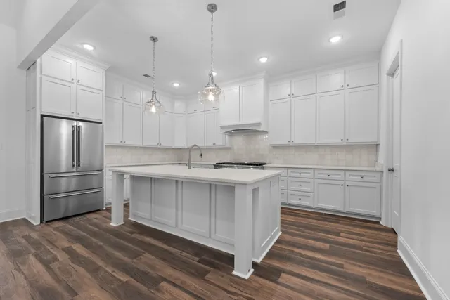 a kitchen with kitchen island a sink stainless steel appliances and cabinets