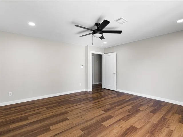 a view of an empty room with wooden floor