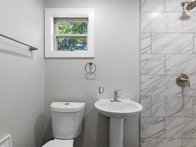 a bathroom with a sink toilet and a mirror