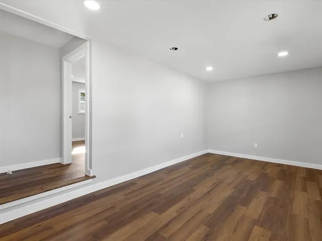a view of empty room with wooden floor and entryway